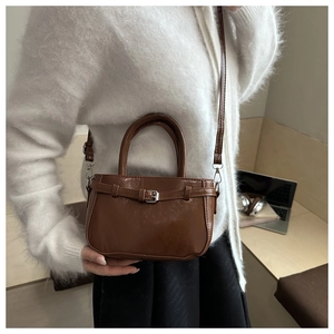 Détail d'un mini sac à main en similicuir marron avec boucle en métal et bandoulière fine