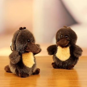 Gros plan du porte-clés peluche ornithorynque marron avec anneau sur bois