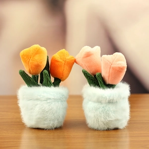 Close-up of cute plush tulip flower pot pendants in orange and pink on a wood surface