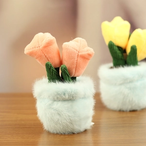 Close-up of plush tulip potted plant decor with pink flowers and soft blue base