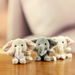 Plush elephant keychain in brown, grey, and white with plaid scarves on wooden surface