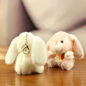 Detailed view of pink plush bunny keychain with carrot bib and soft fur texture