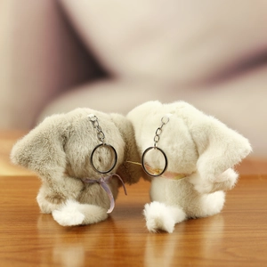 Close-up of plush elephant keychains in grey and cream with soft rainbow ribbons