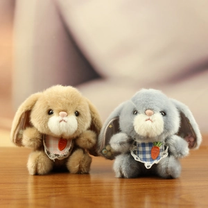 Cute plush rabbit keychain set with lace plaid bibs and sequin star ears on wood background