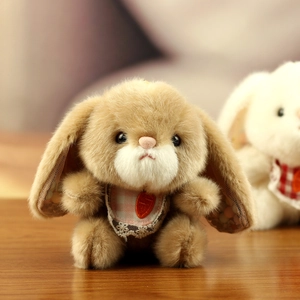 Close-up of plush rabbit with lace bib and carrot detail on a warm wooden background