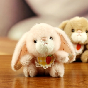 Close-up of a pink plush rabbit with a carrot pattern bib and soft premium fur texture