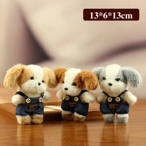 Drie pluche hondenhangers in blauwe denim overal met baby-label op houten tafel