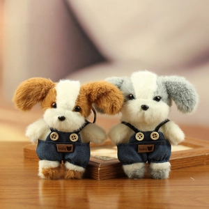 Detail van twee pluche puppy's in blauwe denim overal met baby-patch en sleutelhangers
