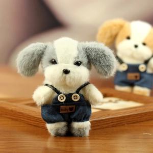 Detail van een pluche honden-sleutelhanger met denim overall, houten knoop en leren label