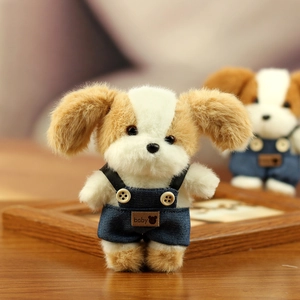 Detail van een pluchen puppy in denim overall met baby-label op houten tafel