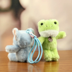 Detail of plush animal charms featuring fluffy frog and koala with a fashion tag