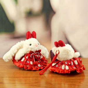 Detail of plush rabbit pendant with sequined red skirt and festive bow decoration