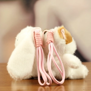 Detailed view of plush animal charms with pink braided lanyards on a wooden surface