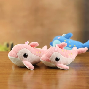 Detail of pink and blue plush dolphins with gold stars on a rustic wooden background