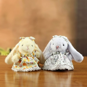 Paire de lapins en peluche avec robes à fleurs et dentelle sur table en bois