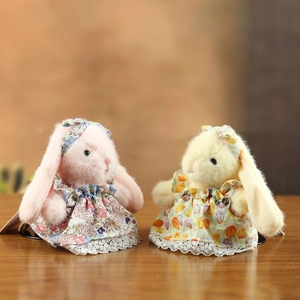 Lapins en peluche mignons en robes fleuries et bandeaux assortis sur bois