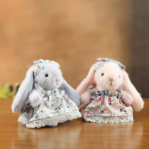 Détail de lapins en peluche gris et rose portant des robes à fleurs et dentelle