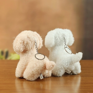 Detail view of curly plush teddy dog keychains showing back texture and metal rings