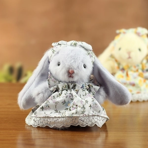 Gros plan d'un lapin en peluche aux oreilles tombantes en robe à fleurs et dentelle