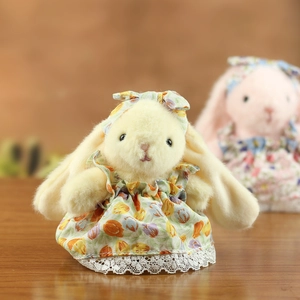 Détail du lapin en peluche portant une robe à fleurs avec une bordure en dentelle blanche