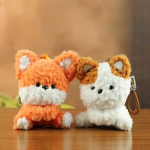Schattige pluizige vos- en hond-pluche sleutelhangers met strikken op houten tafel