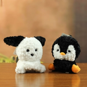 Detail van schattige pluche puppy en pinguïn hangers van zacht korrelig fluweel