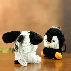 Detailopname van pluche honden- en pinguïnhangers met zachte textuur en witte koorden