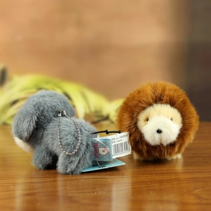 Detail shot of mini plush animal charms with metal bead chains in a cozy setting