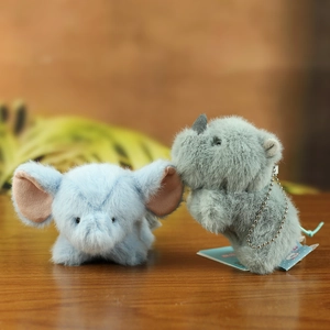 Detailed view of soft plush animal charms with silver ball chains on a wooden surface