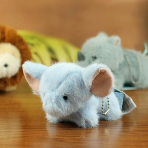 Close-up of soft light blue plush elephant pendant with metal bead chain on wood table