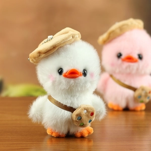 Close-up of plush duckling pendant with brown beret and mini palette crossbody bag