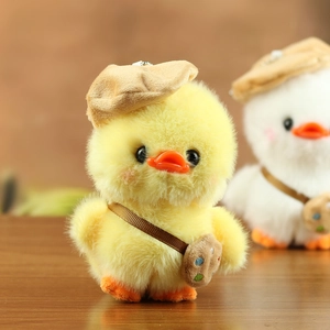 Close-up of plush yellow duck charm with brown beret and tiny artist palette bag
