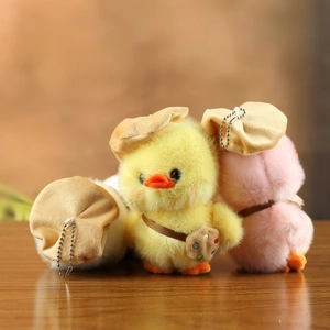 Detailed view of three plush ducks in yellow pink and white with hats and mini bags