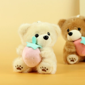 Dettaglio del portachiavi orsetto di peluche con fragola e ricamo morbido sulle zampe