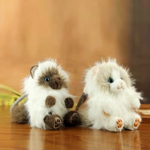 Close-up of fluffy plush cat keychains in Siamese and grey-white patterns with soft fur
