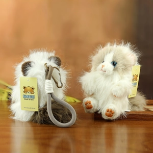 Close-up of cute plush cat keychains with long faux fur on a rustic wooden table