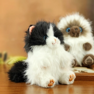 Close-up of realistic plush cat charms with fluffy fur and pink paw pad details
