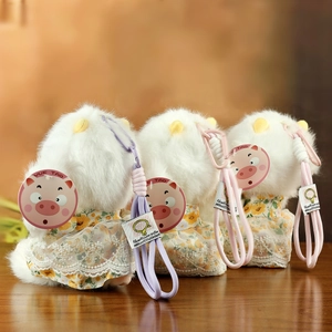 Detailed view of three plush lamb keychains with floral fabric and delicate lace trim