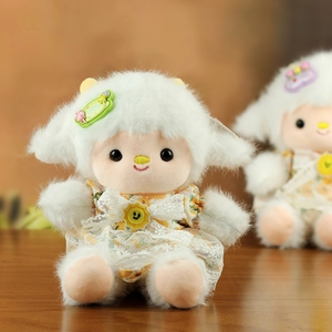 Close-up of a plush lamb doll wearing a yellow floral dress with a green Happy hair clip