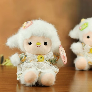 Detail of plush lamb toy in yellow floral dress with sunflower and Smile accessory
