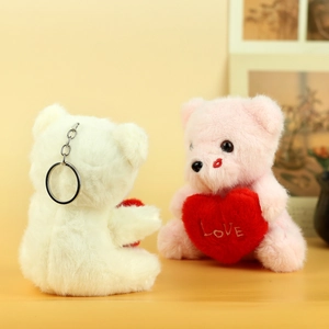 Macro detail of plush teddy bear charms with embroidered red hearts and metal keyrings