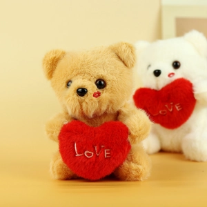 Detailed shot of two teddy bears holding red plush hearts with LOVE embroidery