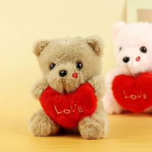 Detailed view of plush teddy bear with embroidered red heart and gold LOVE lettering