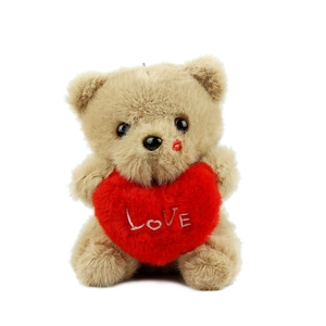 Cute brown plush teddy bear holding a red Love heart with a red kiss mark detail