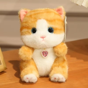 Close-up of cute plush cat with blue eyes and pink heart pendant on wooden table