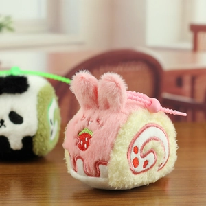 Detalle de peluche conejo swiss roll rosa con bordado de fresa y cadena de cuentas