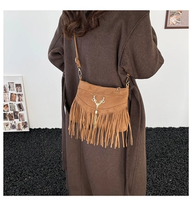 Détail d'un sac à bandoulière marron à franges avec accessoire en métal doré