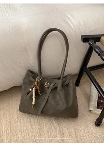 Detail of dark grey retro suede tote bag with metal buckle and wooden bead tassel