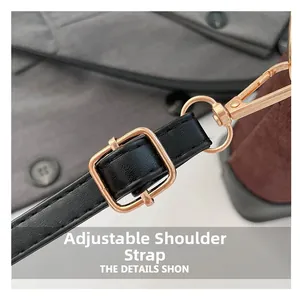 Detail of adjustable black leather shoulder strap with bronze metal buckle and lobster clasp