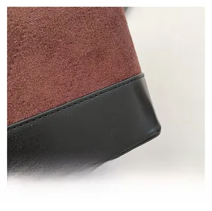 Detail of caramel suede and black leather stitching on a stylish crossbody bag